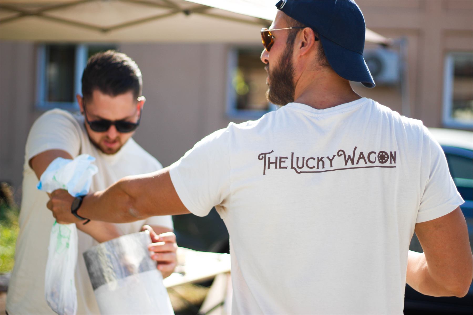 Deux bénévoles portant le t-shirt The Lucky Wagon lors d'une action de tri
